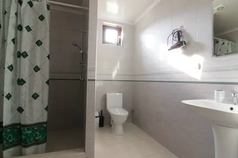 Ванна кімната з душем, умивальником і феном у Котеджі 2